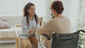 A woman sitting on the couch talking to another person.