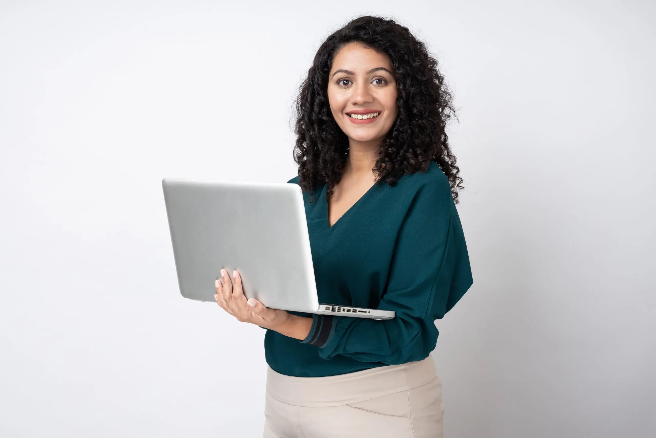 Portrait of young businesswoman with curly hairstyle wear trendy smart casual outfit isolated on white background stock photo A woman holding a laptop in her hands.