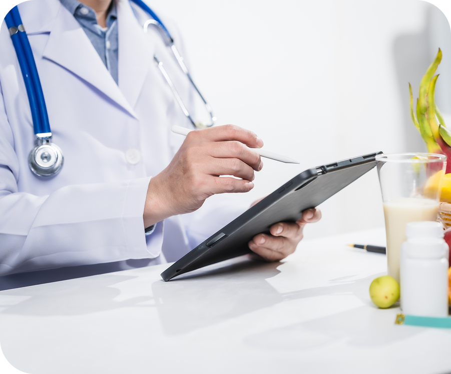A doctor is using his tablet computer at the table.