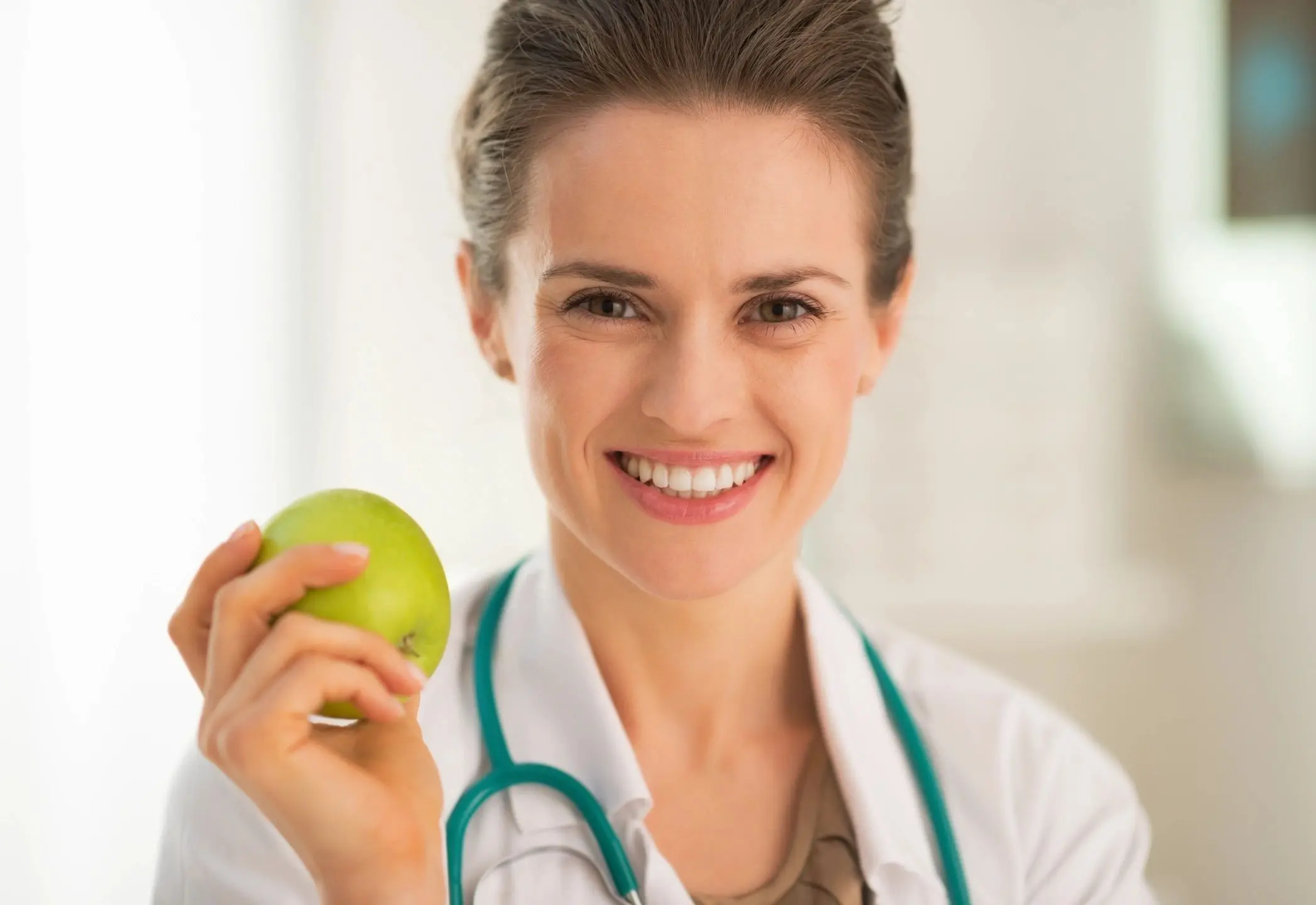 qtq80-h32eQy A woman holding an apple in her hand.