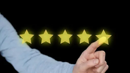 A person pointing to five stars on a black background